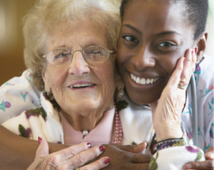 woman and caregiver embracing and smiling